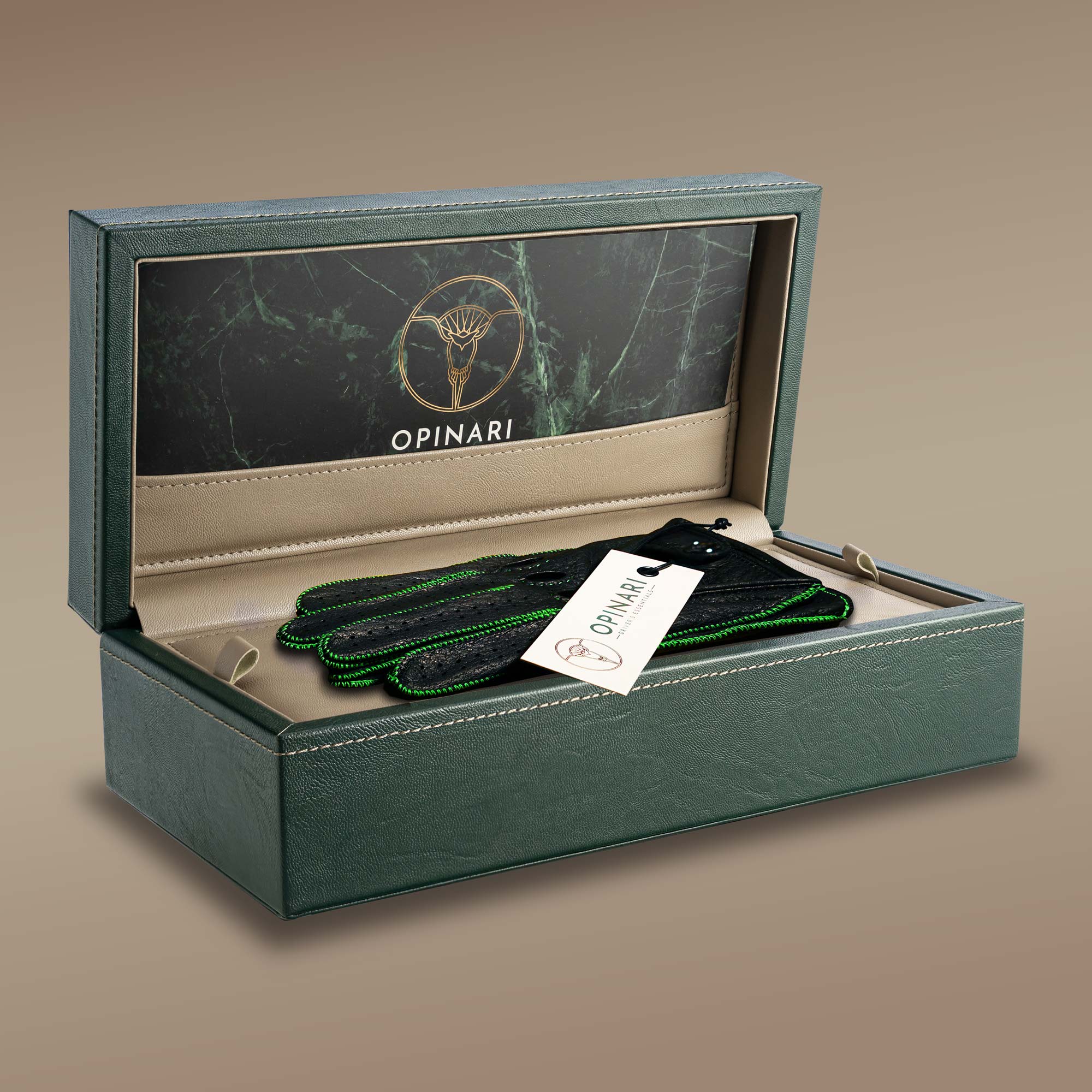 Black driving gloves with hell green stitching laying in a green watchbox