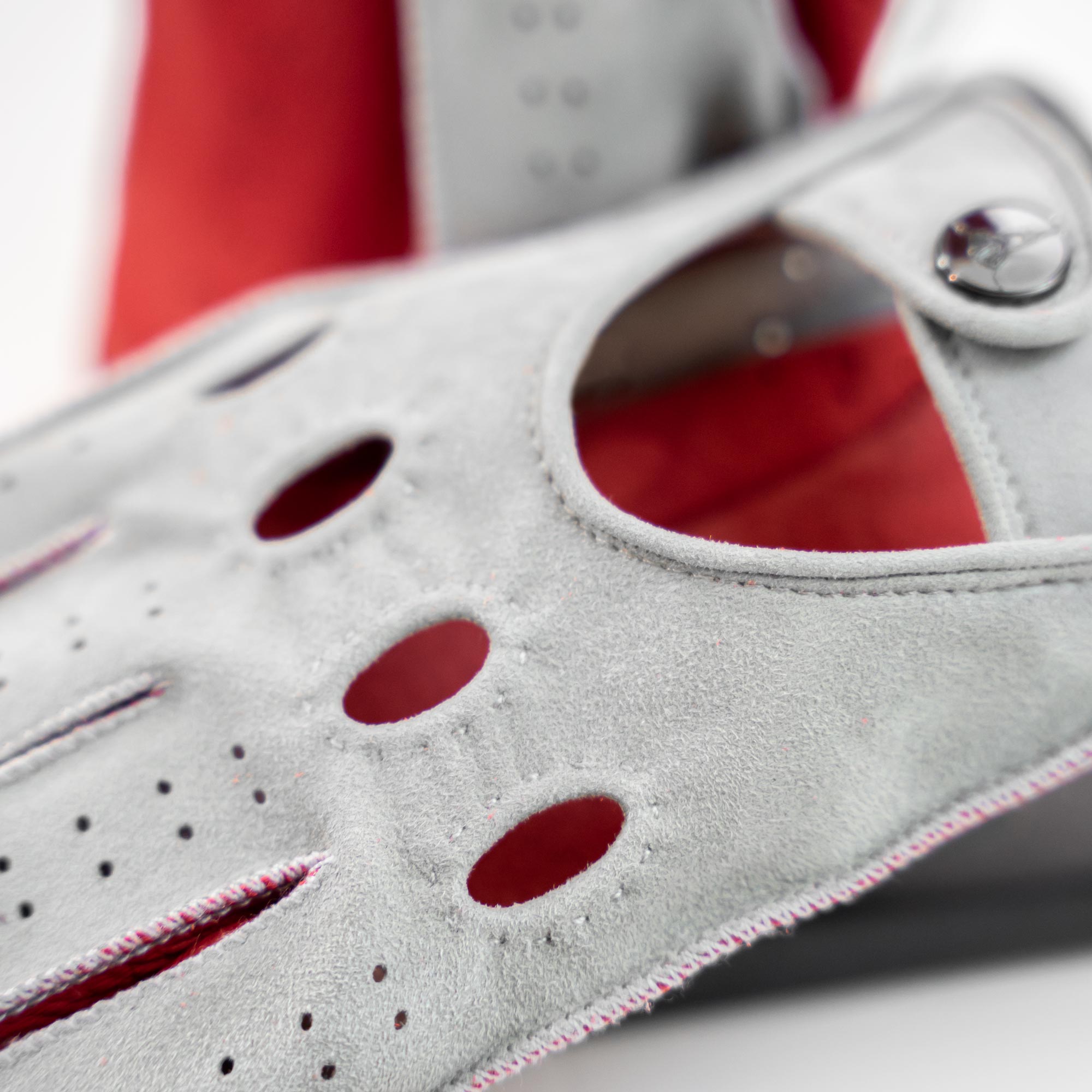 Close-up of a gray glove with red accents on a blurred background